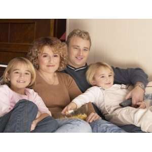  Family Cuddled Up on the Couch Watching Television 