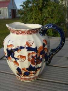   comes AN OLD ENGLISH POLYCHROME FLOW BLUE CREAMER WITH PANELED BODY