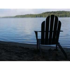  A Classic Adirondack Chair is Silhouetted by a Lake in New 